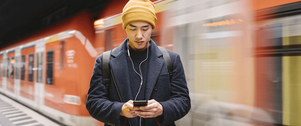 Man using a phone by a train