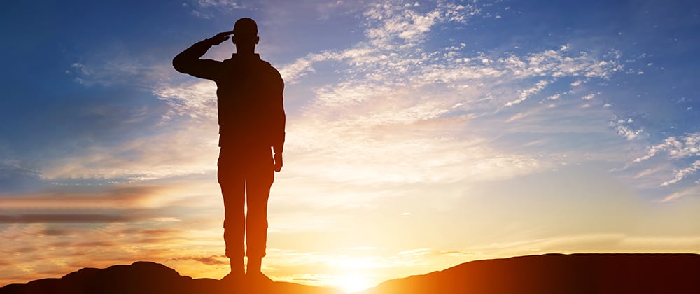 Man saluting with the sun in the background