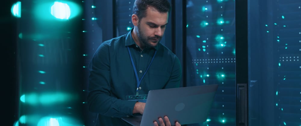 Man using a laptop in a server room