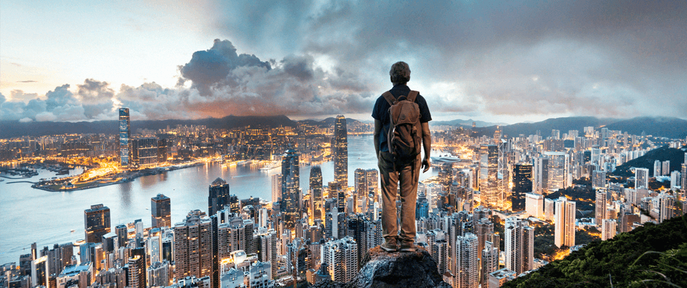 Man standing on a rock overlooking a city