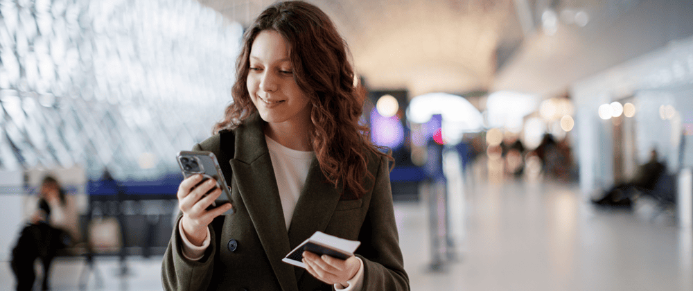 Woman using a phone and holding a passport