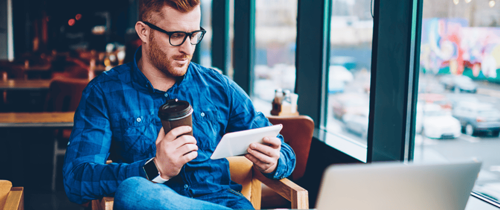 Man holding a phone and coffee