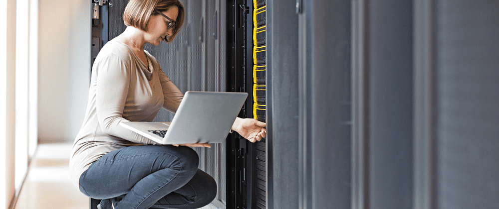 Woman using a laptop in a server room