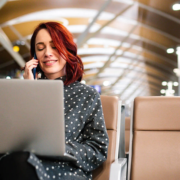 mulher ao telefone sentada com laptop no lobby