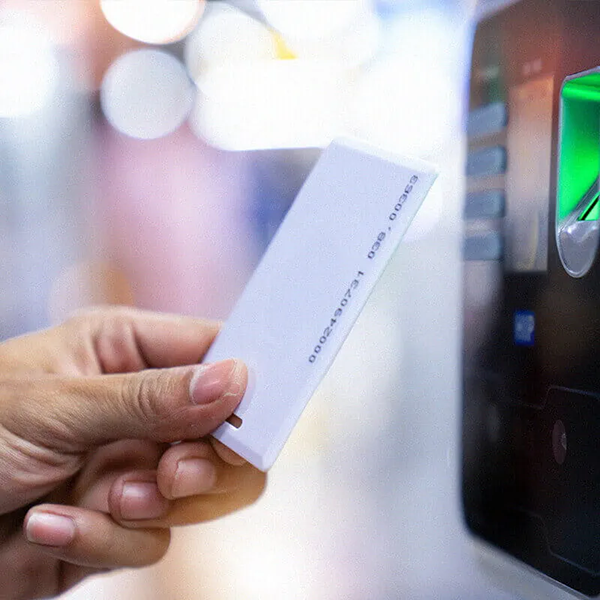 Hand mit ID-Karte in der Nähe des Kartenschlitzes der Maschine