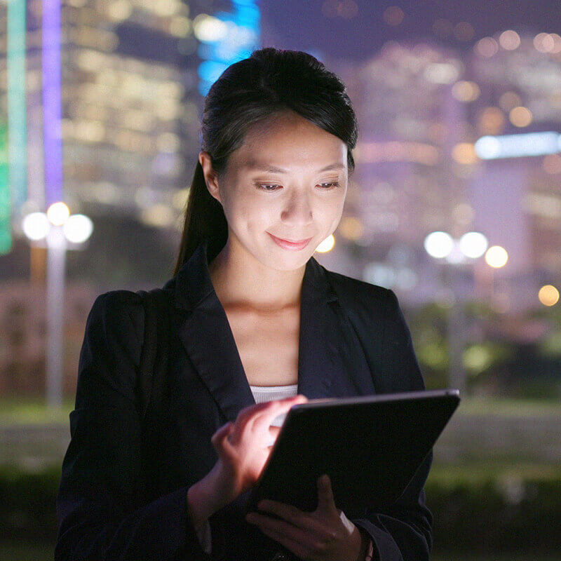 woman looking down on and tapping on tablet