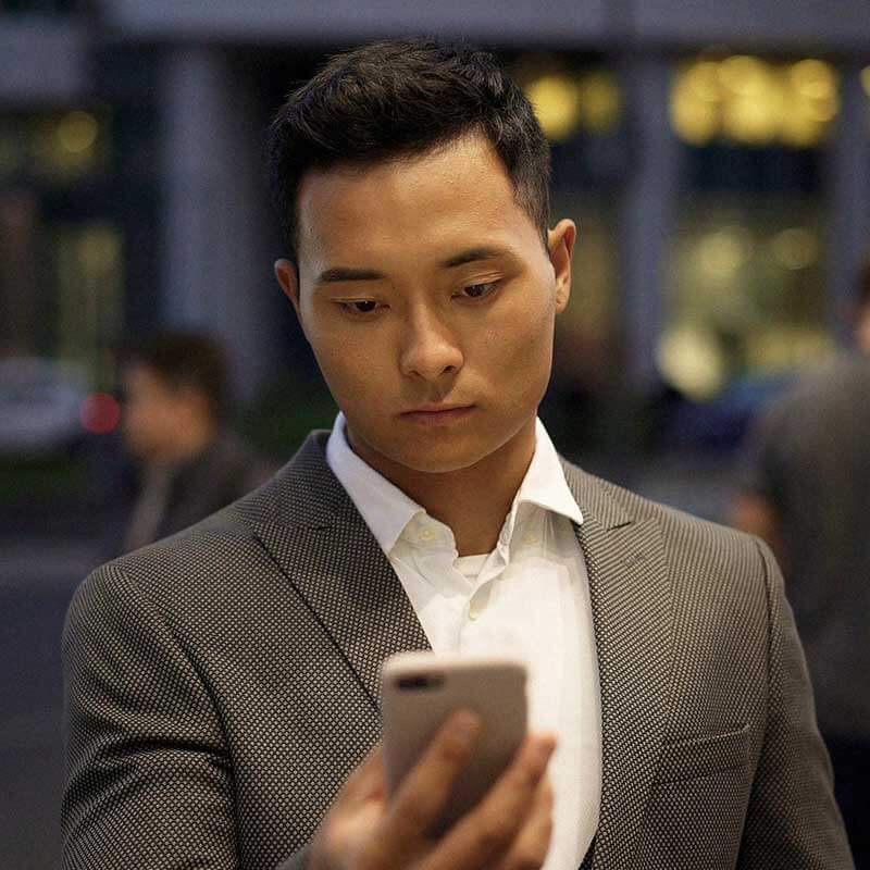мужчина смотрит на экран мобильного телефона