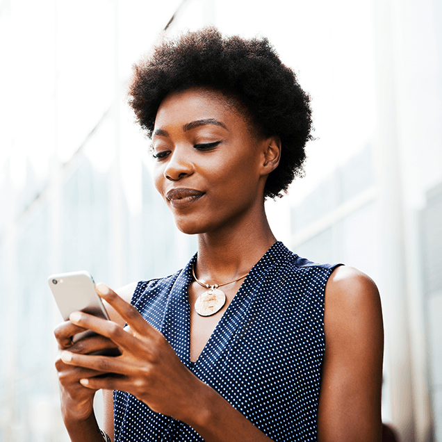 woman looking down at phone held in two hands