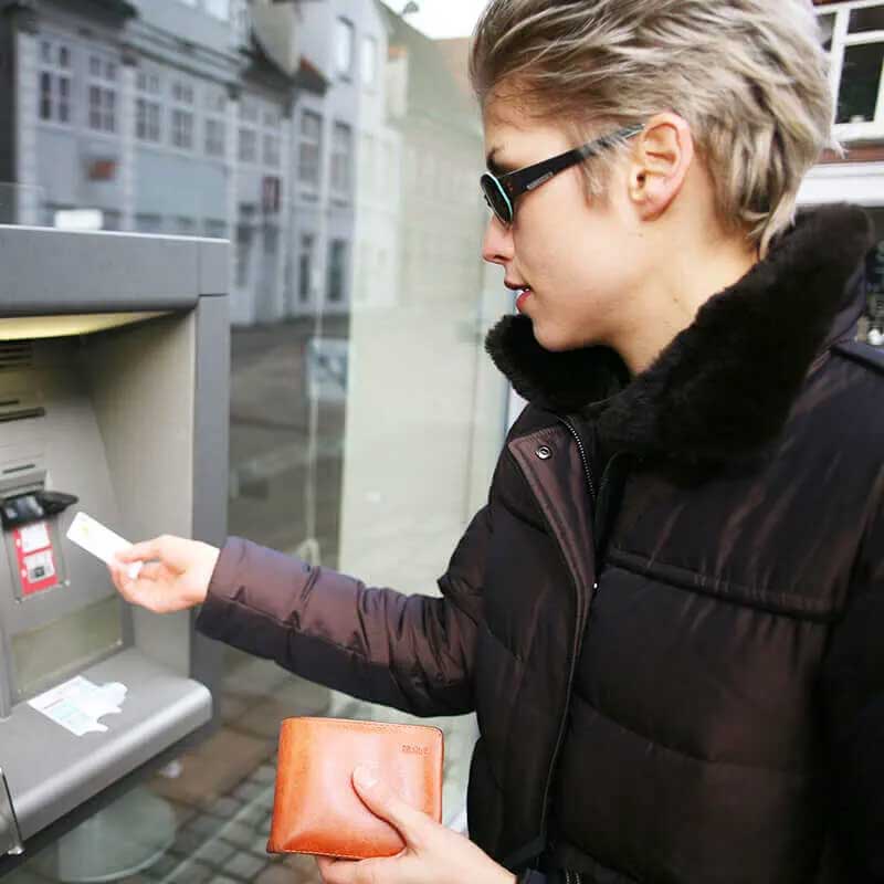 Persona che esegue la scansione di una carta finanziaria in un bancomat