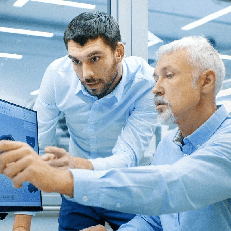 deux hommes pointant vers un ordinateur