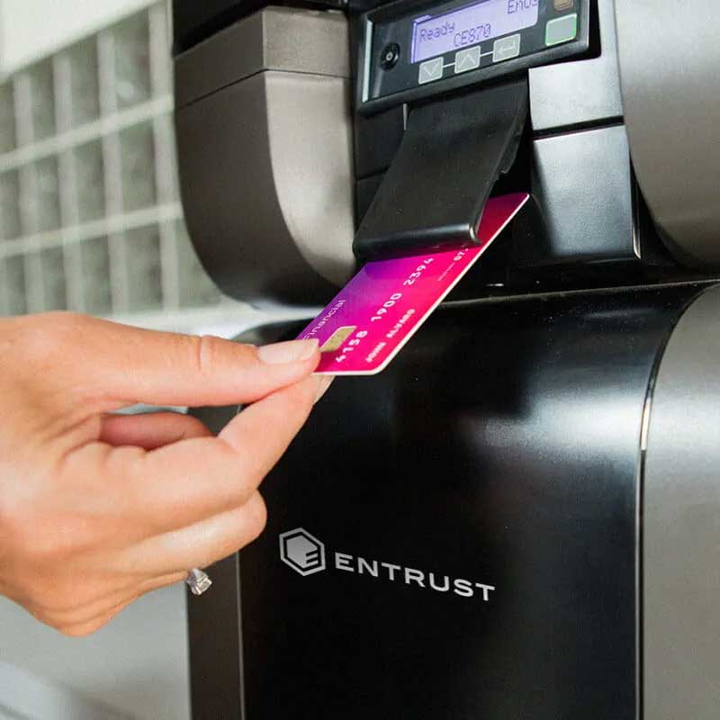 Frauenhand nimmt Debitkarte aus einem Automaten