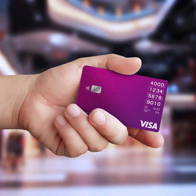 Человек держит в руке платежную карту Visa