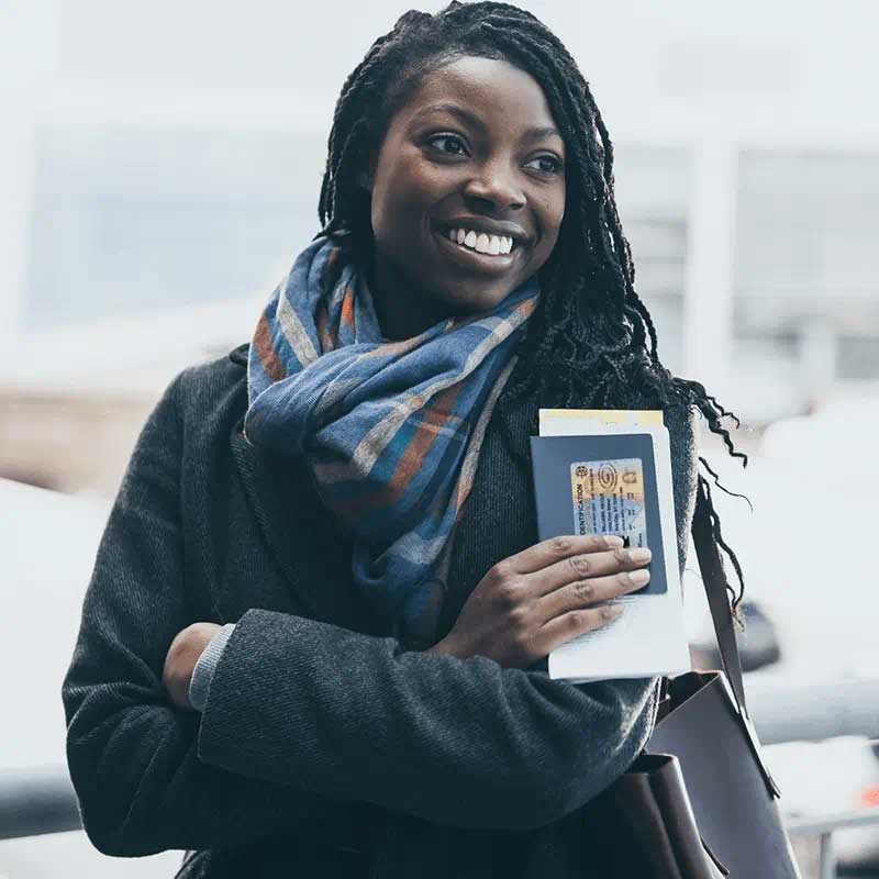 woman holding passport and smiling