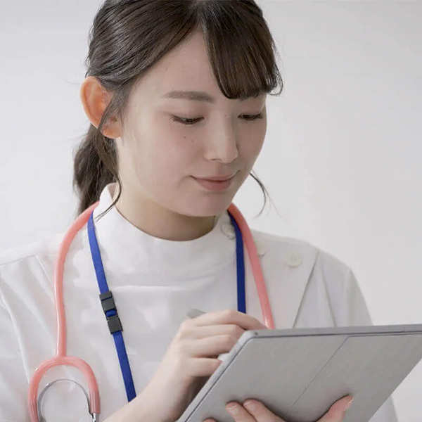 タブレットを見下ろし、タップしている女性医師