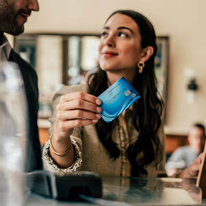 Женщина держит в руке платежную карту