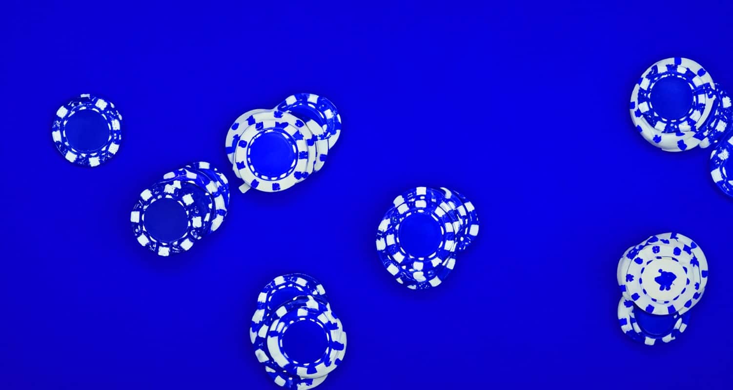 blue and white poker chips on blue background