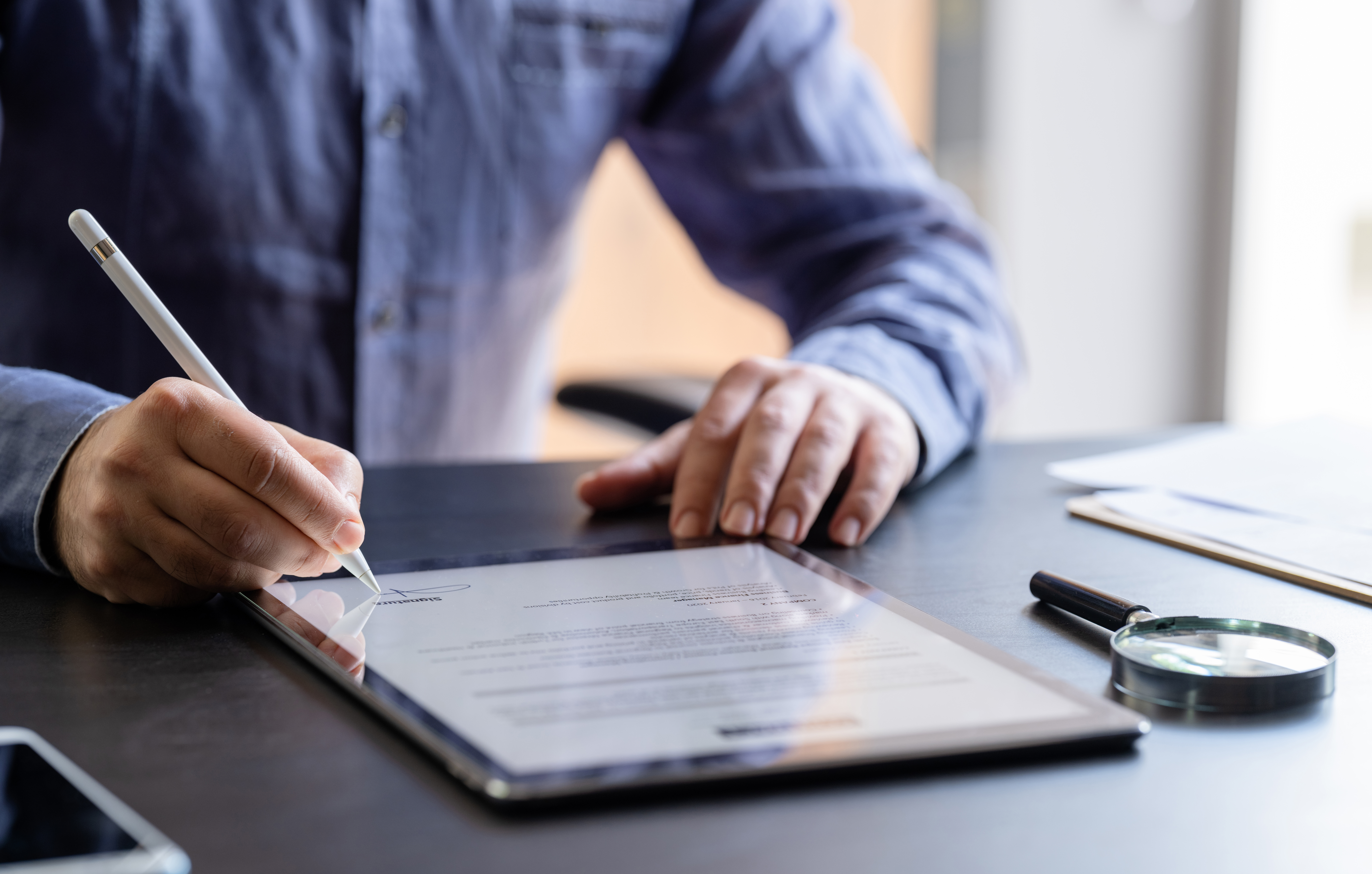 A man sitting at a table and using a tablet