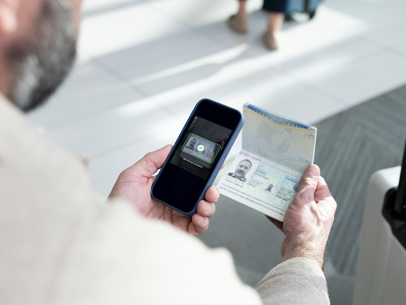 Ein Mann scannt einen Reisepass mit seinem Handy.