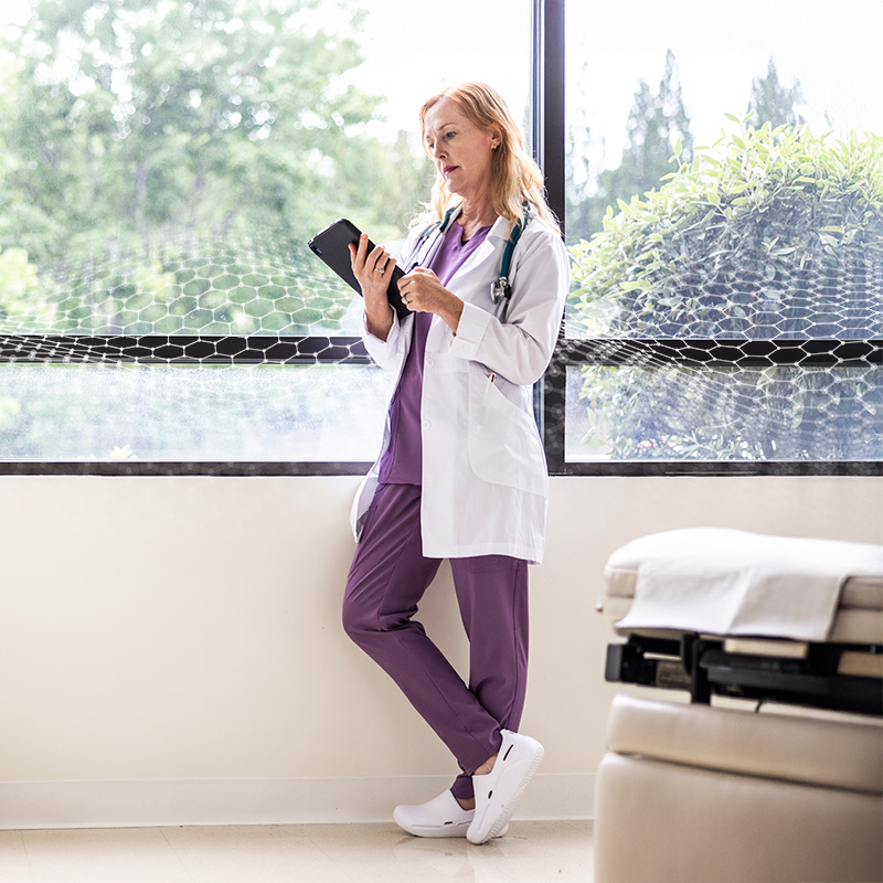 healthcare worker on tablet by window