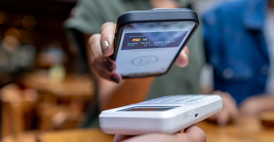 person uses mobile phone to pay with a digital credit card