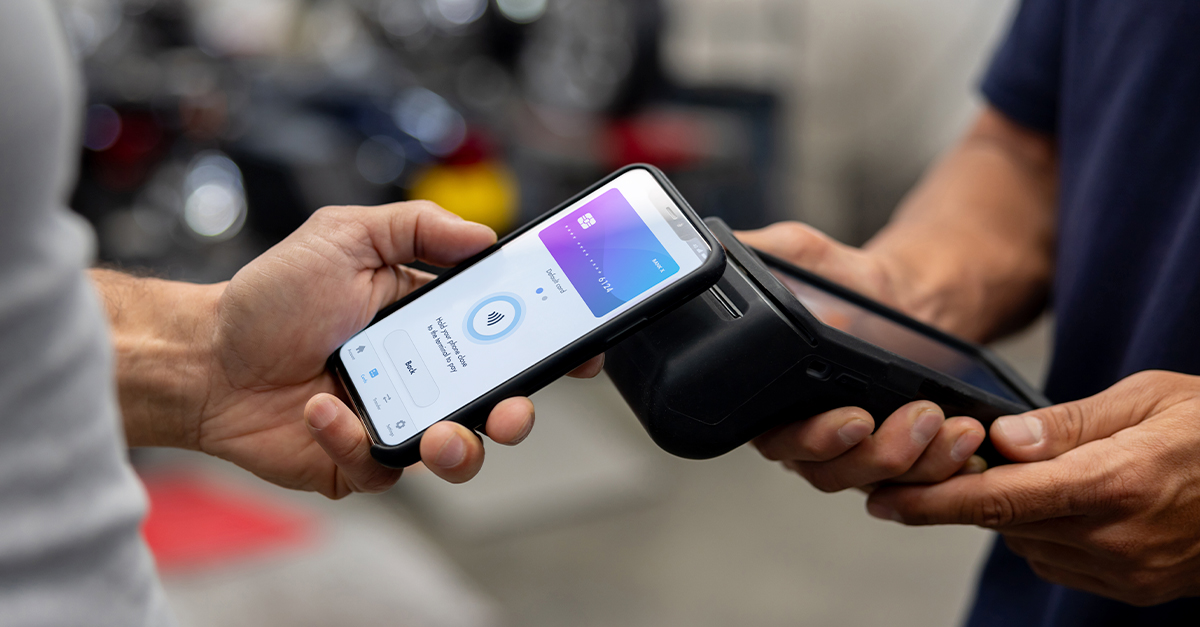 Smartphone making a contactless payment by tapping a handheld card reader