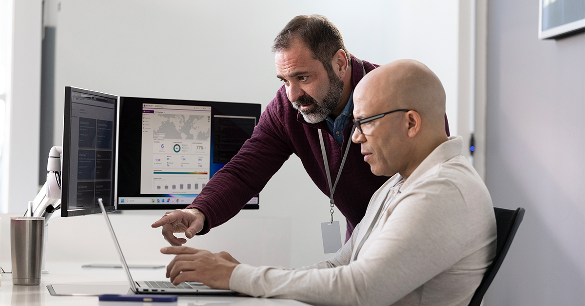 two male colleagues at a computer