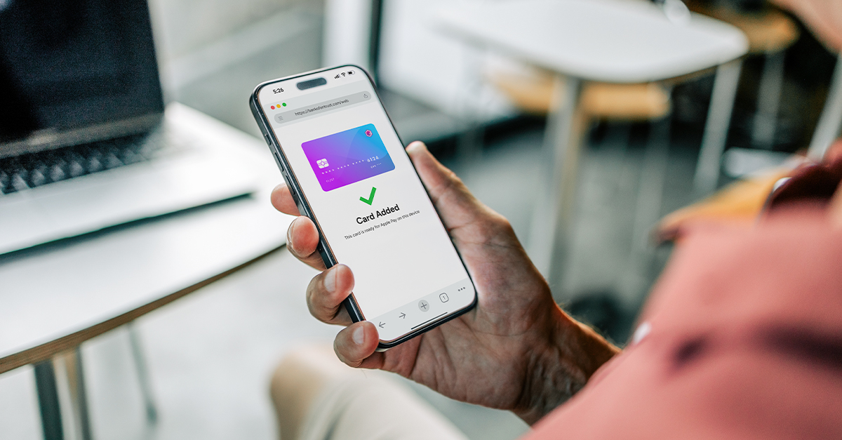 Hand holding a phone showing a ‘Card Added’ confirmation screen