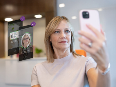 Person taking a selfie while identity verification interface appears on screen