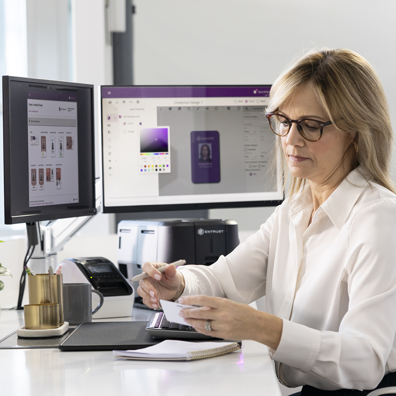 Person designing and printing ID cards at workstation