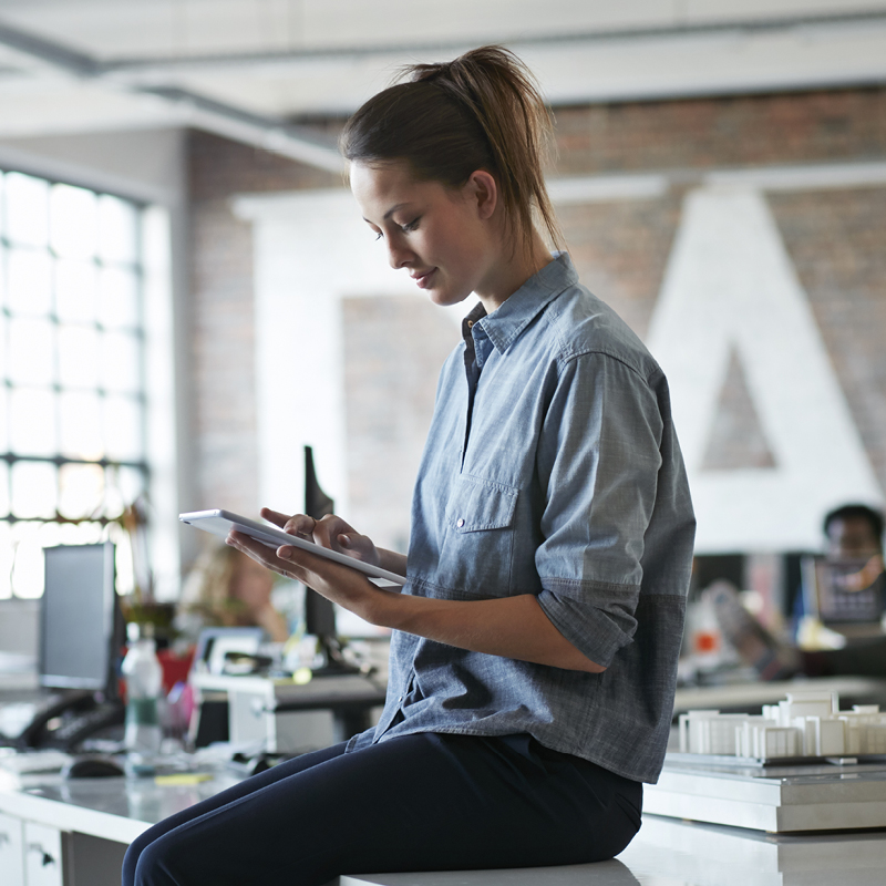 Person using tablet while sitting on office desk