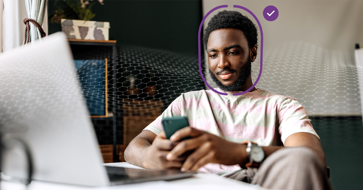 A man sitting down and using a phone