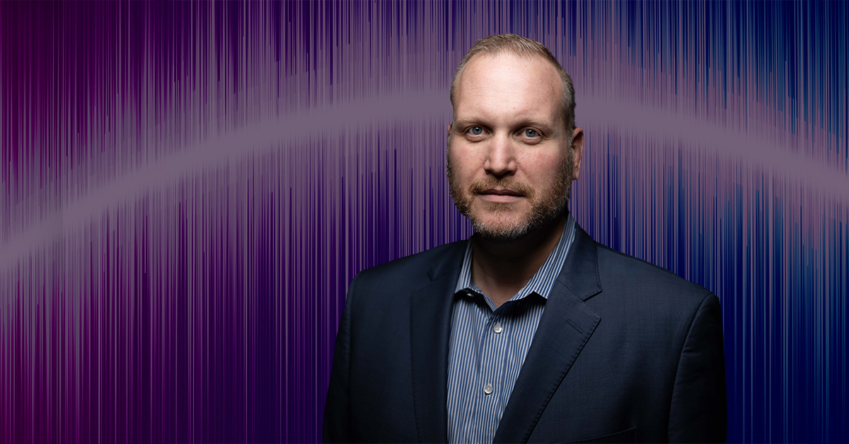 Portrait of person in suit with colorful waveform background