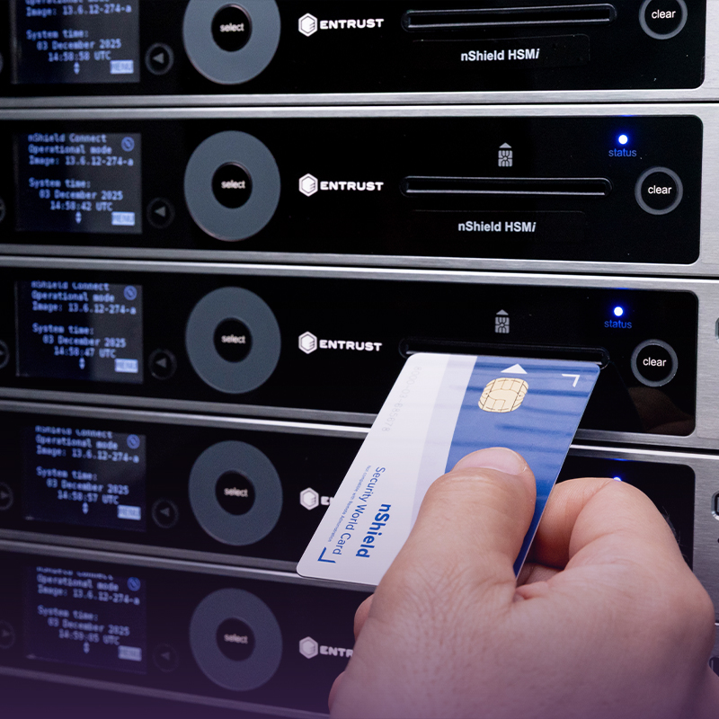 Hand holding smart card in front of Entrust nShield HSM devices in server rack