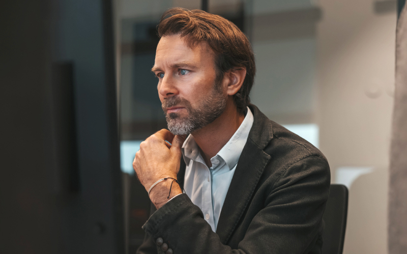 man with hand on chin looking at monitor