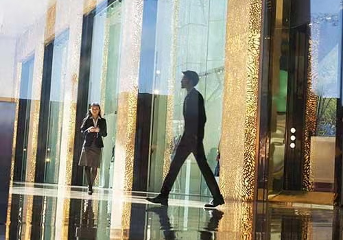 people walking in front of glass building
