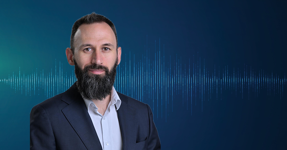 Portrait of a person in a suit with a blue audio waveform background