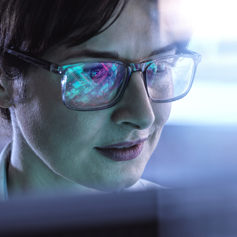 close up of woman in glasses looking at monitor