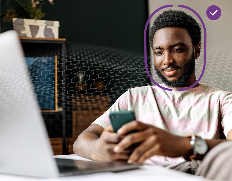 A man sitting down and using a phone