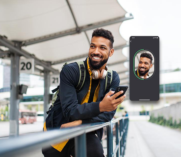 man smiling at screenshot of digital identity on phone