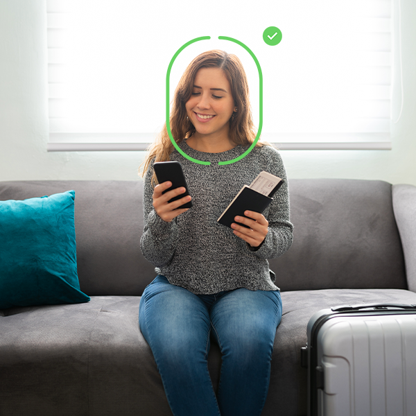 Person using facial recognition on a smartphone while holding a passport