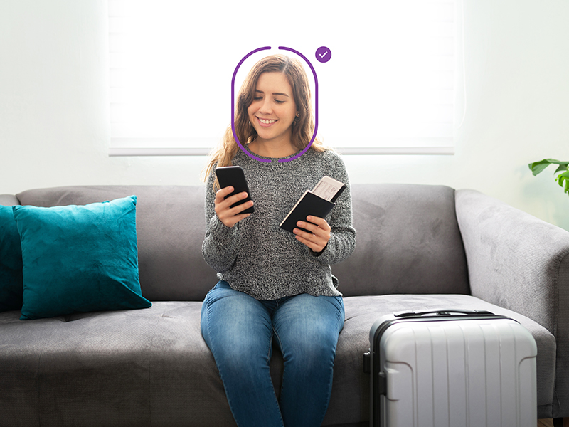 A person sitting on a couch holding a phone using authentication software 