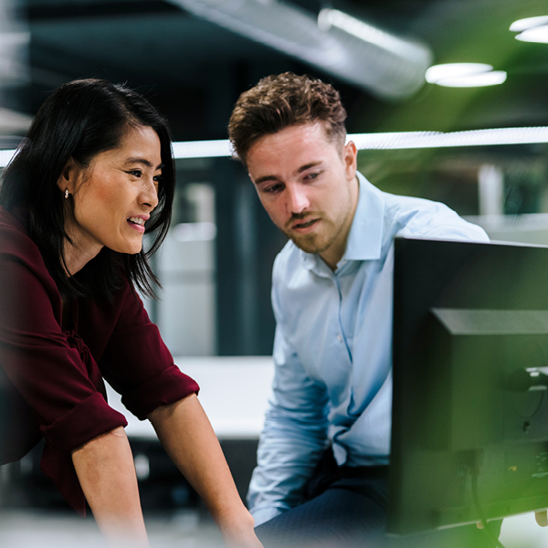 two people looking at computer screen in office