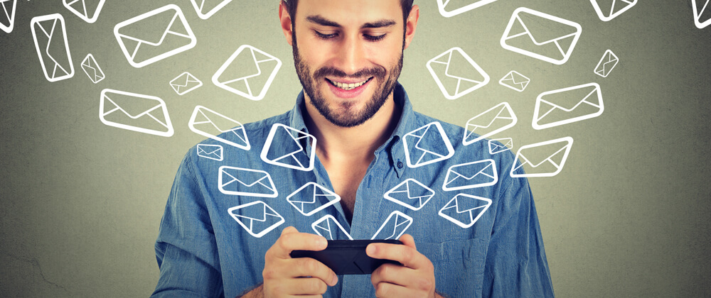man on mobile phone with email icons